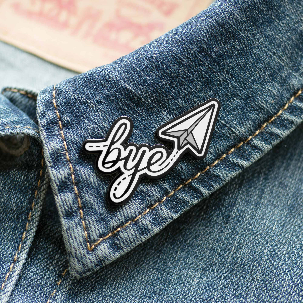 Bye Paper Airplane hard enamel pin on denim jacket
