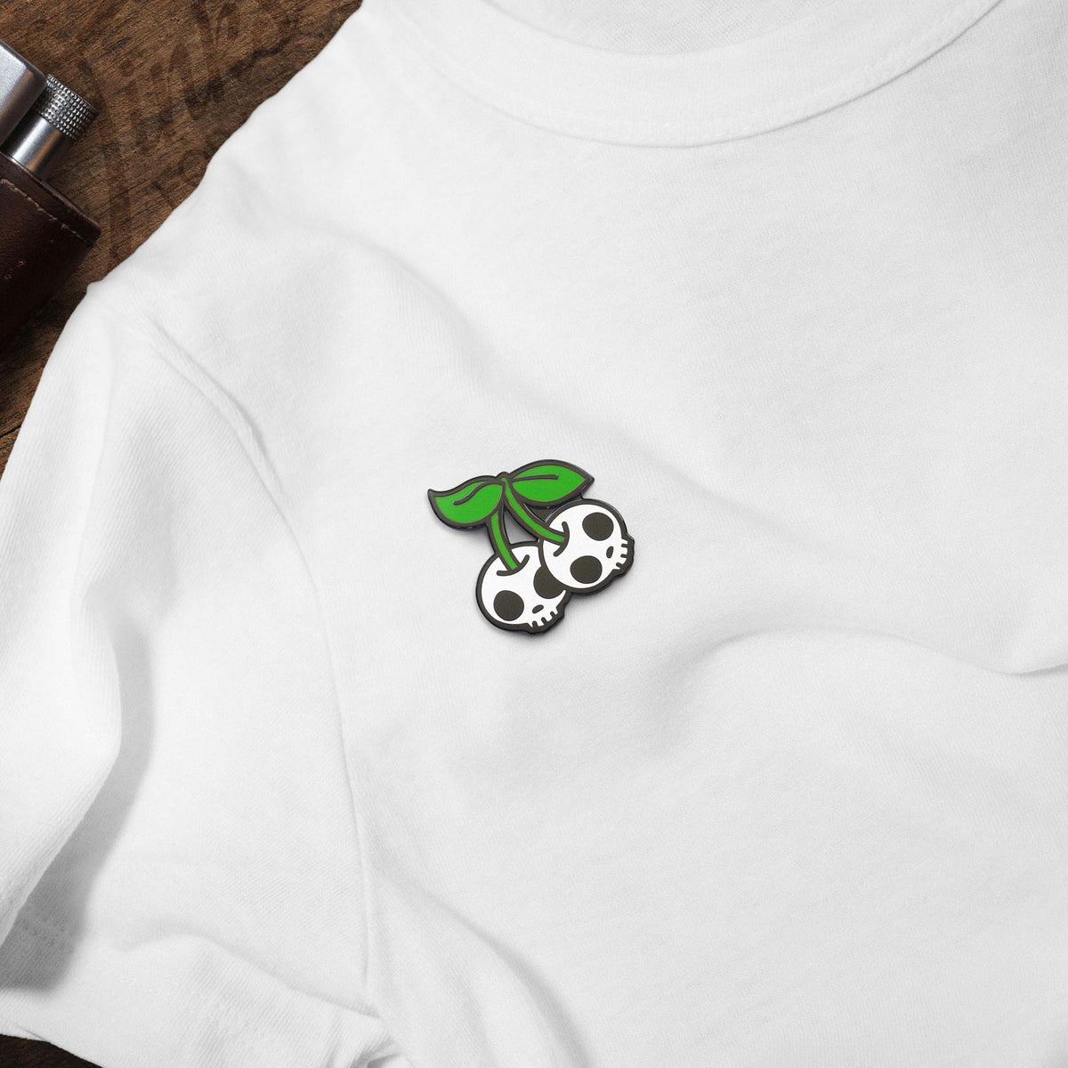 Cherry Skulls hard enamel pin on white t-shirt