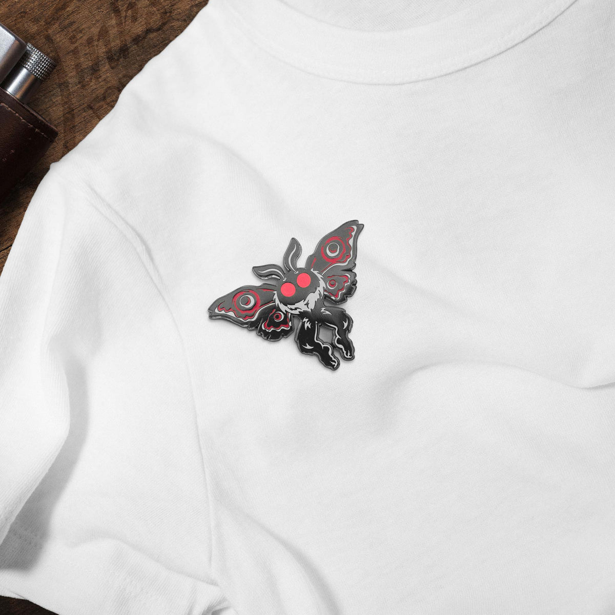 Mothman Cryptid Creature hard enamel pin on white t-shirt