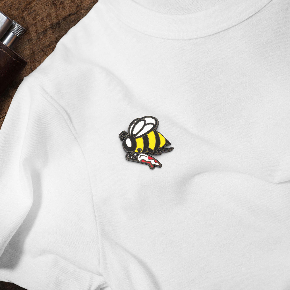 Busy Little Killer Bee Holding Knife hard enamel pin on white t-shirt