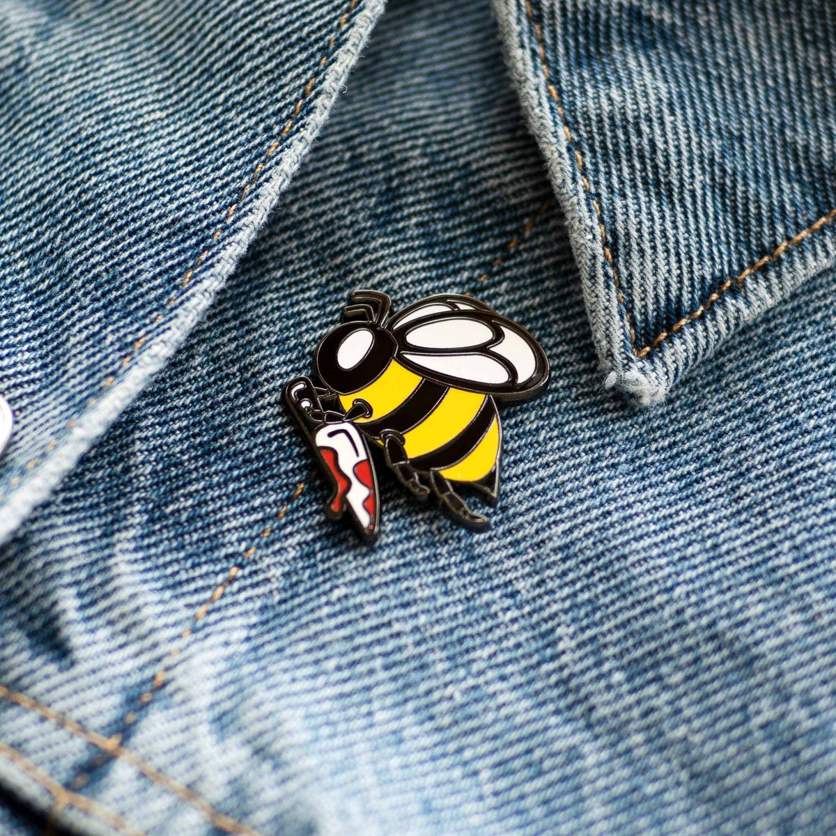 Killer Bee Holding Knife hard enamel pin on denim jacket